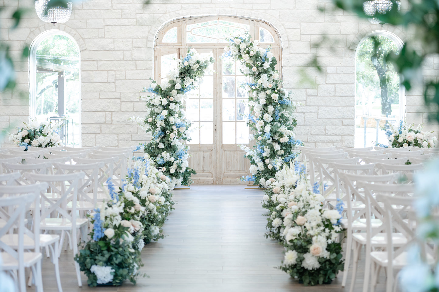 Lone Star Okas chapel styled with Lush blue and white arch, aisle pieces and urns highlighting the beauty of the space and the flowers 