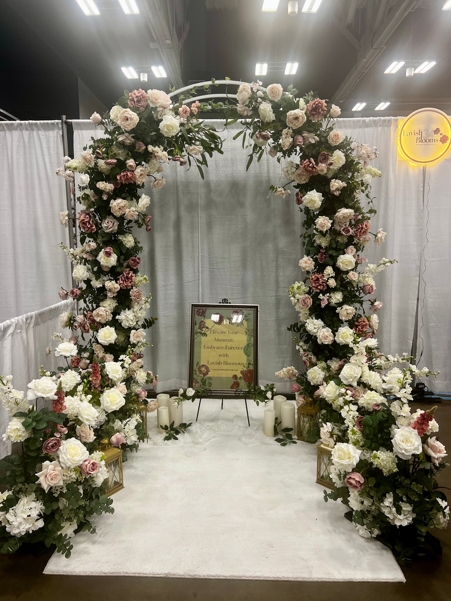 Wedding Expo booth highlighting pink and white arch and aisle pices on display