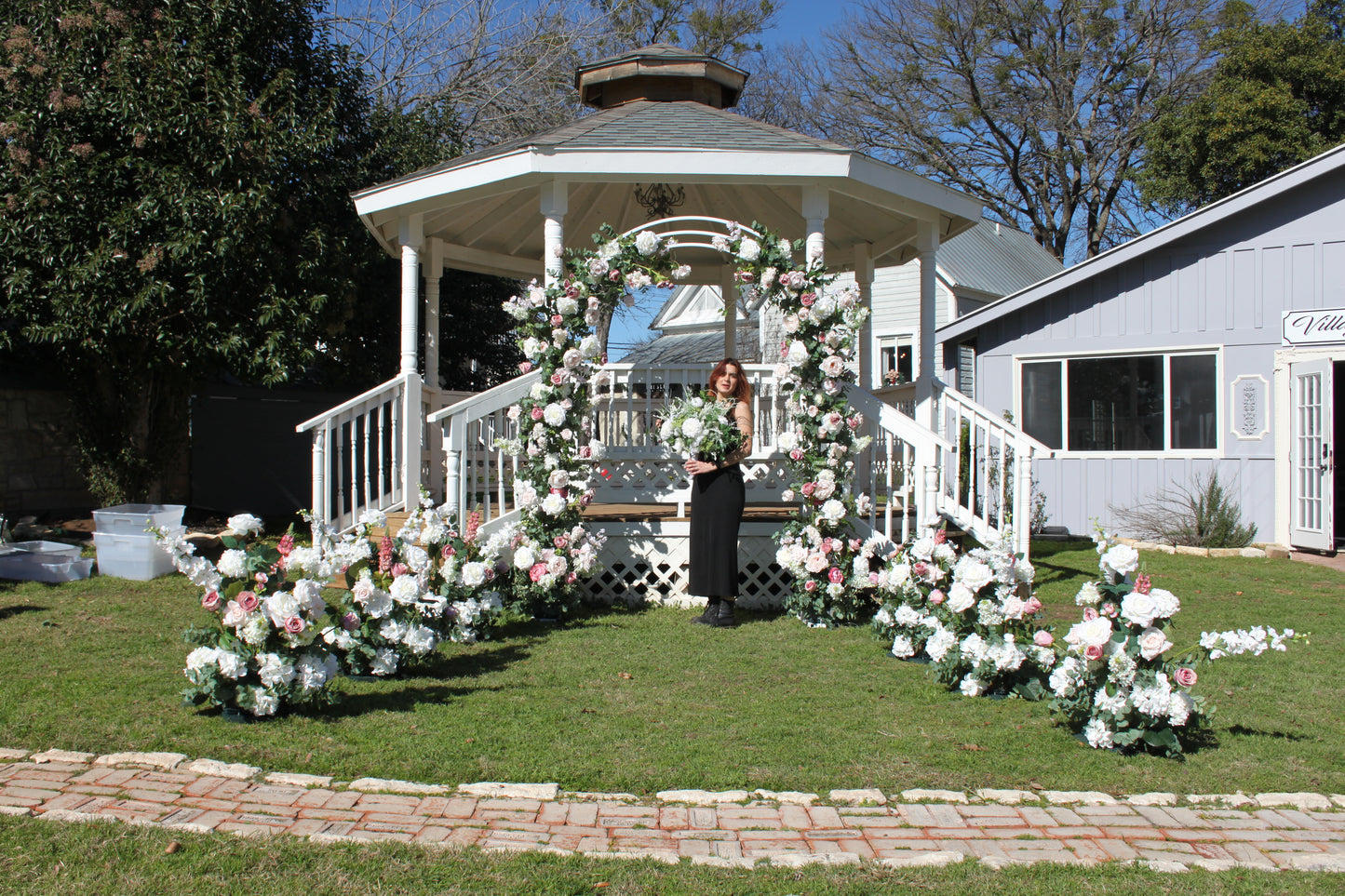 Behind the scenes setting p pink and white arch in a Gazebo at the Village Venue in Salado.