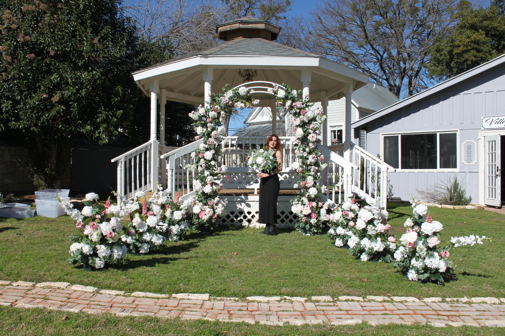 Behind the scenes setting p pink and white arch in a Gazebo at the Village Venue in Salado.