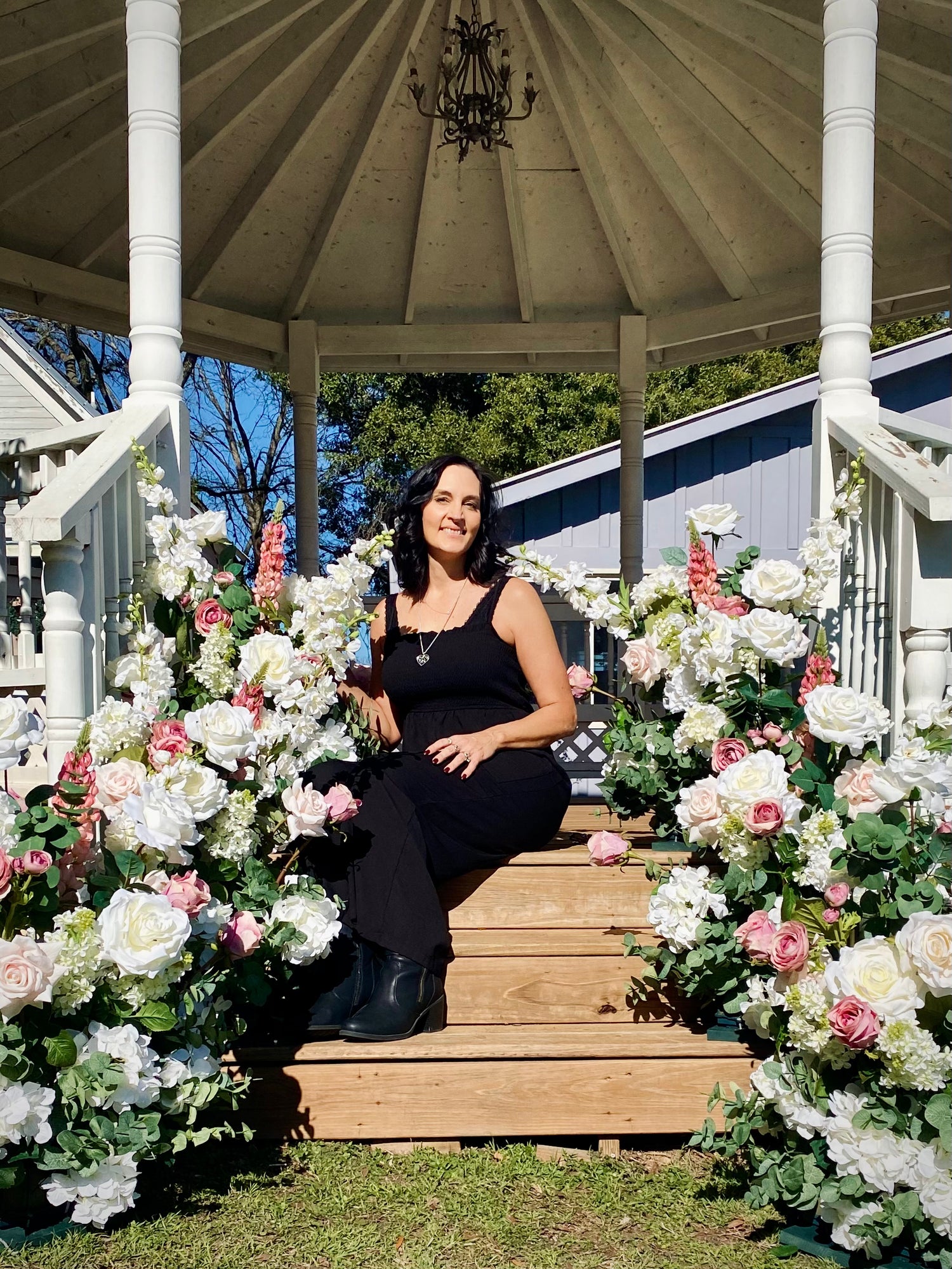 Kellie sitting in a gazebo surrounded by Lush Blushing Bride aisle meadows