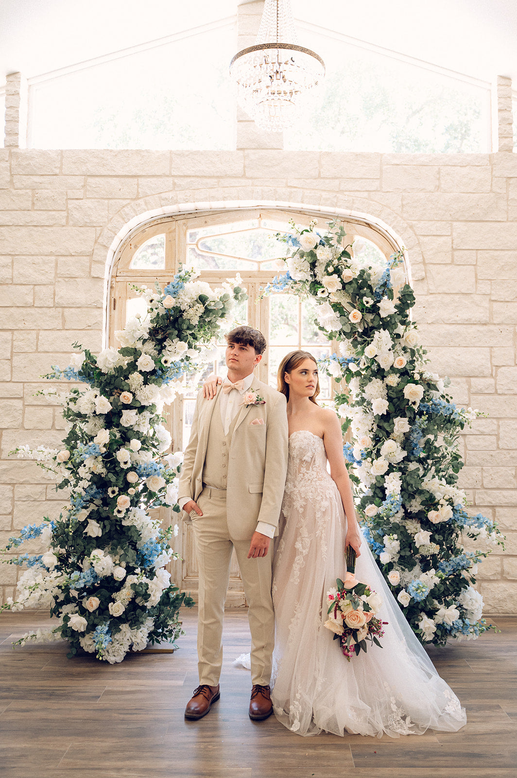 A bride & groom in front of the Something Blue  Arch at the Lone Star Oaks Chapel
