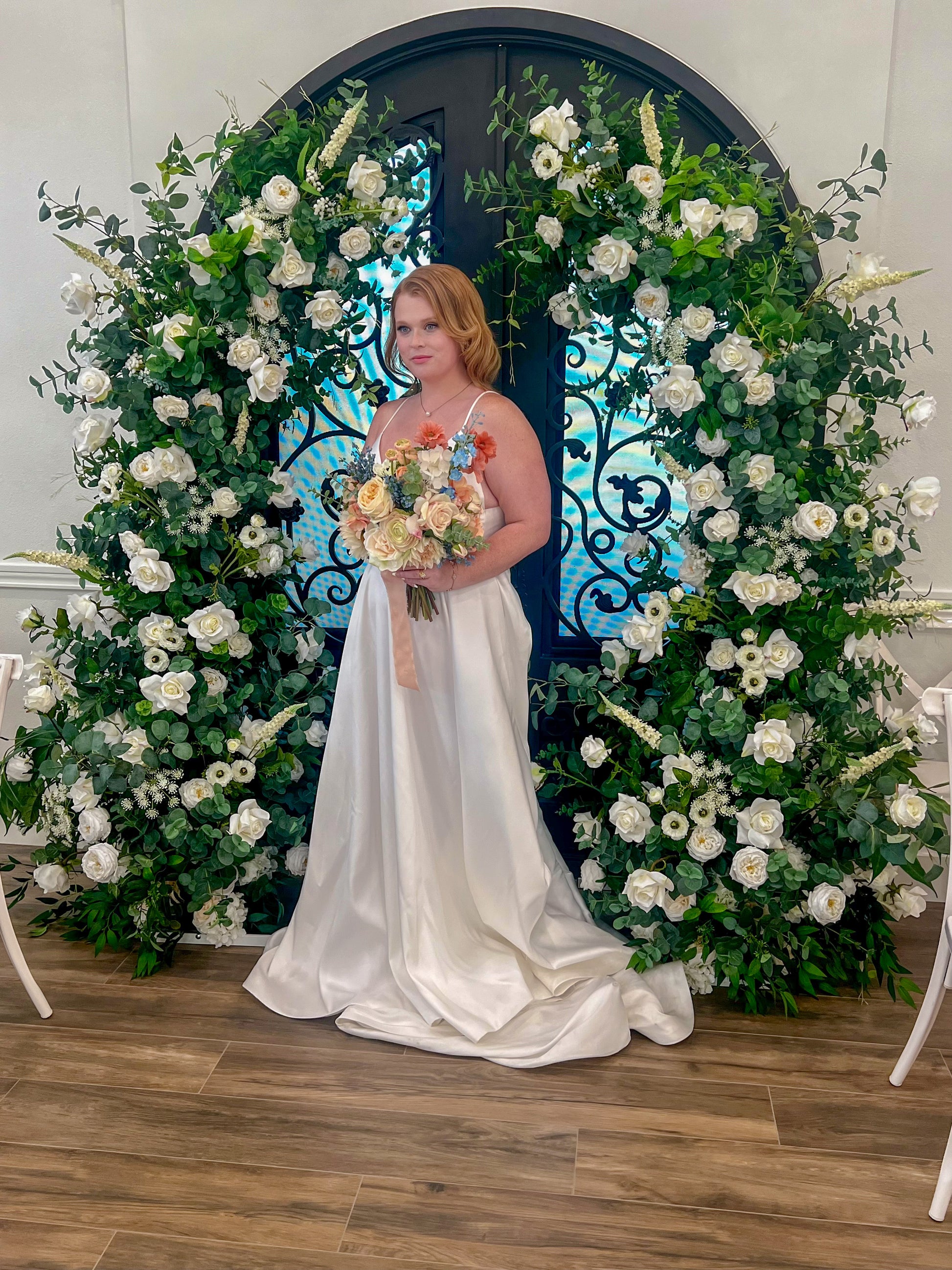 bride in front of the garden arch, a greenery based garden style wedding floral arch